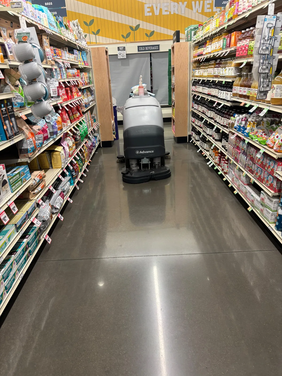 Floor scrubber working the aisles of an open store